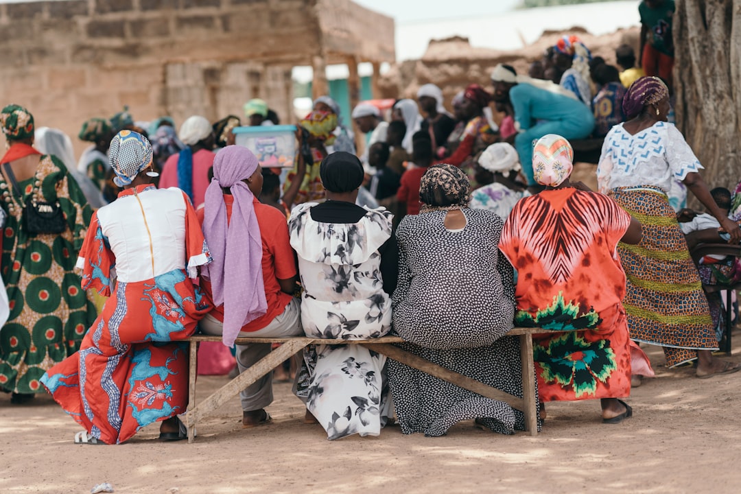 Women in colorful clothes sitting on a bench outdoors.