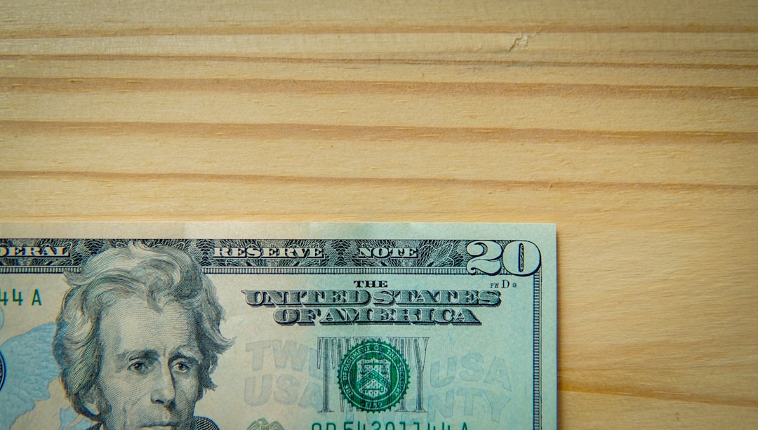 A twenty-dollar bill on a wooden table.
